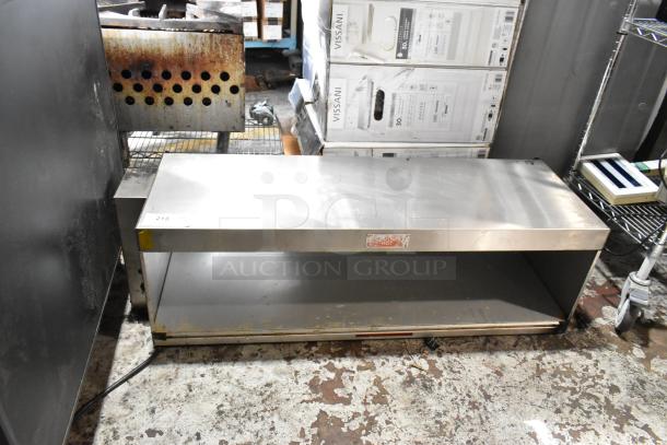 Stainless steel kitchen shelf with open storage, used condition, visible wear. Label reads "Caution: Hot." Tag number 213.