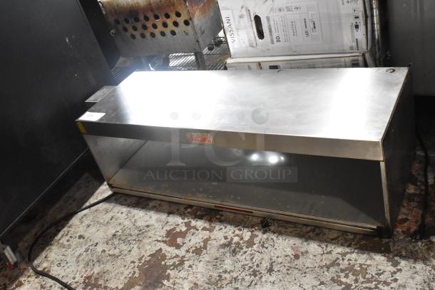 Stainless steel commercial kitchen hood, used, rectangular, with front warning label for heat caution.