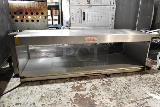 Stainless steel warming shelf, used condition, visible wear. Caution "Hot" label on front, electrical cord attached.