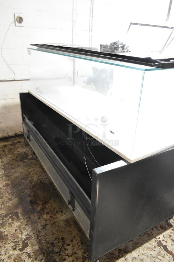 Large glass display case with black metal base, open front storage area, and sliding top panel. Appears in used condition.