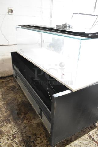 Large glass display case with black metal base, open front storage area, and sliding top panel. Appears in used condition.