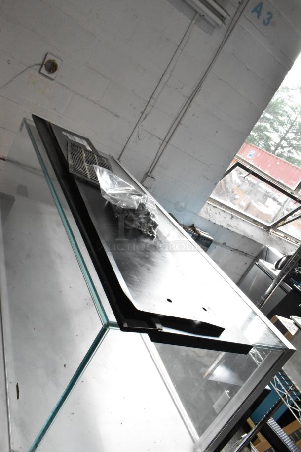 Black metal vent panel, new condition, with mounting hardware bag. Ventilation slots visible on top surface.