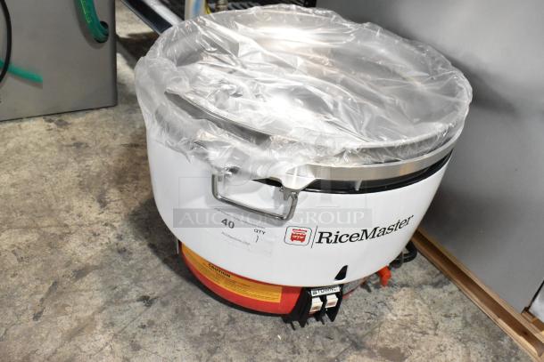 RiceMaster commercial rice cooker, plastic-wrapped, used condition, model markings and quantity label attached.