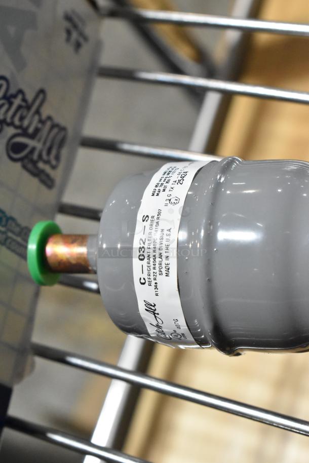 Gray refrigerant filter drier, Model C-032-S, for R134a/R12/R404A/R507, labeled "Made in USA," in new condition.