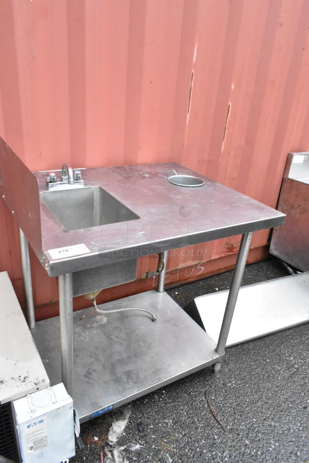 Stainless steel utility sink with faucet and strainer hole, visibly used condition. Tag "218" attached to the corner.