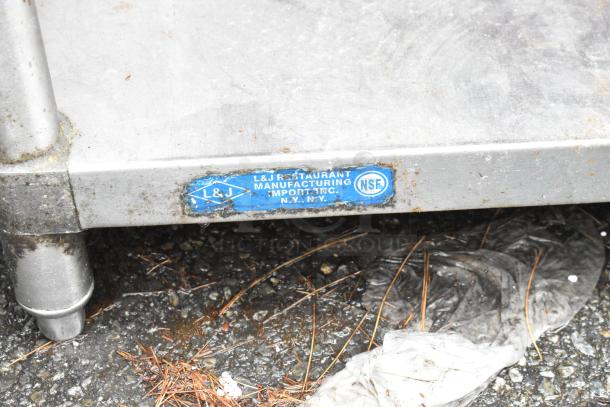 Stainless steel table with L&J Restaurant Manufacturing label. NSF certified. Used condition with visible wear and rust.