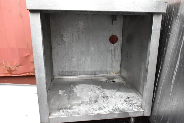 Stainless steel industrial cabinet with a hollow interior, showing signs of wear and rust, suitable for storage.