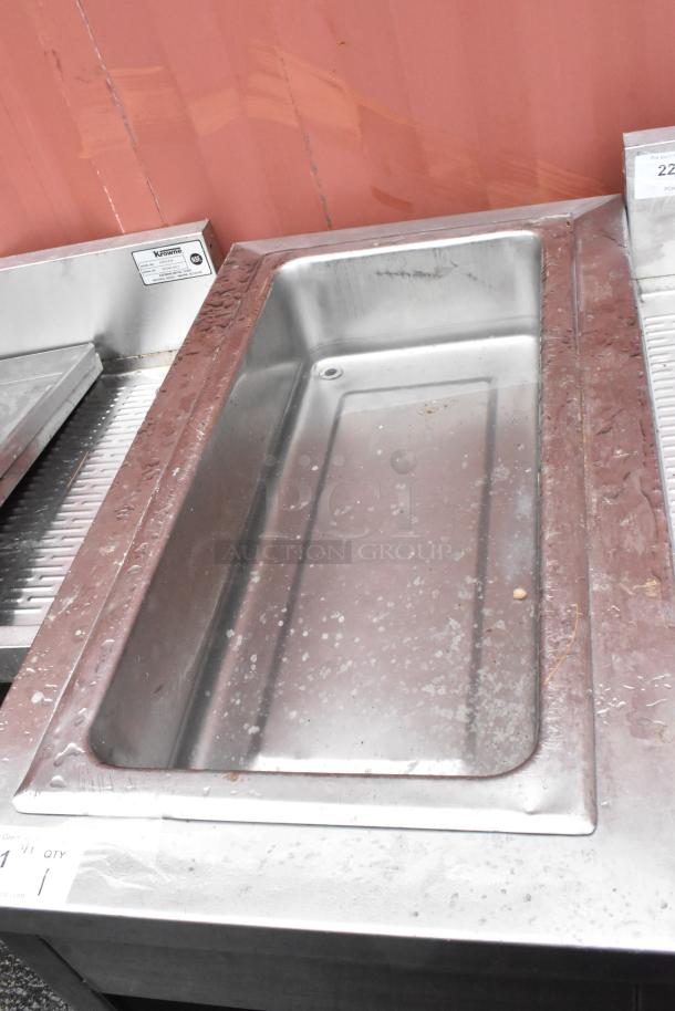 Stainless steel sink unit with visible wear, featuring a single deep basin. Krowne label, model HSA-10, confirming commercial use.