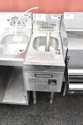 Stainless steel hand sink with dual faucets, integrated soap dispenser, and "Employees must wash hands" sign. Used condition.