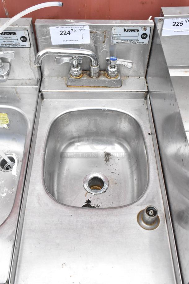 Stainless steel Krowne sink with dual faucets, signs of rust and wear. Label indicates NSF certification. Auction tag visible.
