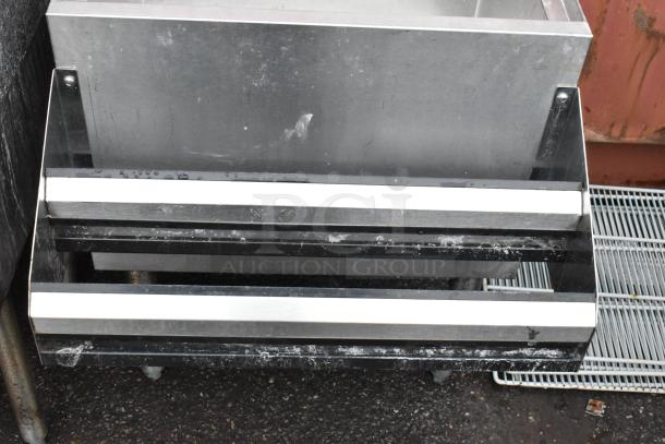 Commercial stainless steel steps with black frame, minor surface wear, suitable for industrial kitchen use.