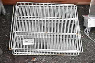 Stack of metal wire shelving, light rust spots, quantity label indicates 5 units. Suitable for storage or retail use.