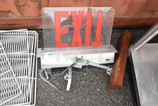 Metal and acrylic exit sign with mounting bracket, slightly worn, numbered tag "227" from PCIauctions.com, for sale.