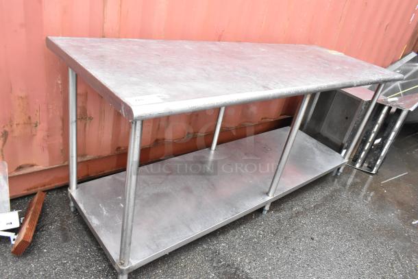 Stainless steel work table with lower shelf. Used condition, shows wear. Ideal for kitchen or industrial use.