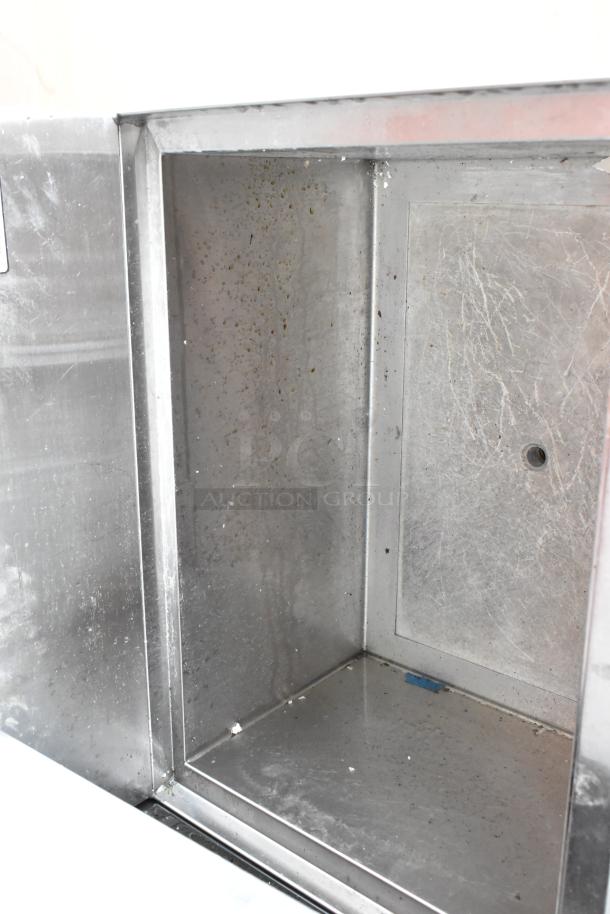Stainless steel oven interior showing signs of use with scratches and residue, indicating the need for cleaning.