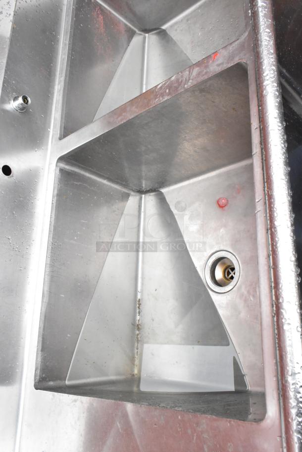 Stainless steel commercial sink with three compartments, showing visible wear. Ideal for restaurant use.