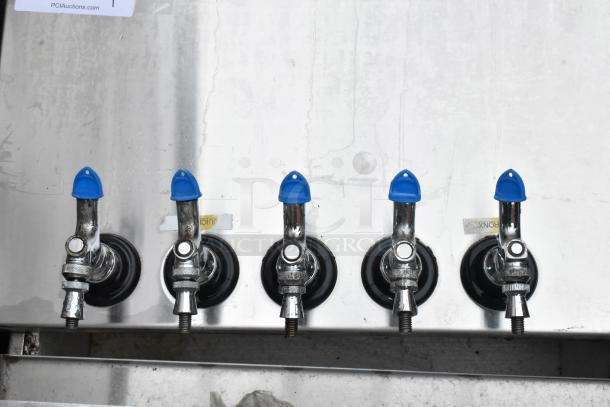 Five stainless steel beverage taps with blue covers, mounted on a metal surface. Appears in good condition.
