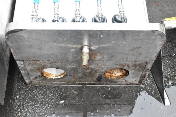 Commercial stainless steel beverage dispenser, five taps with blue handles, visible rust and wear, suitable for restoration.