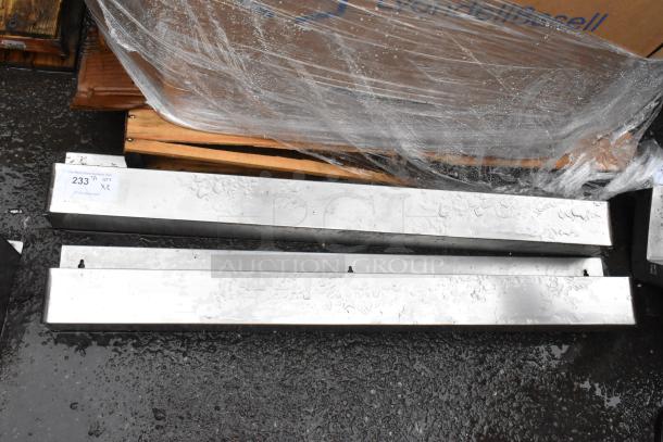 Two aluminum rectangular beams, wet surface, placed on a pallet. Visible tag reads "233" indicating auction lot number.