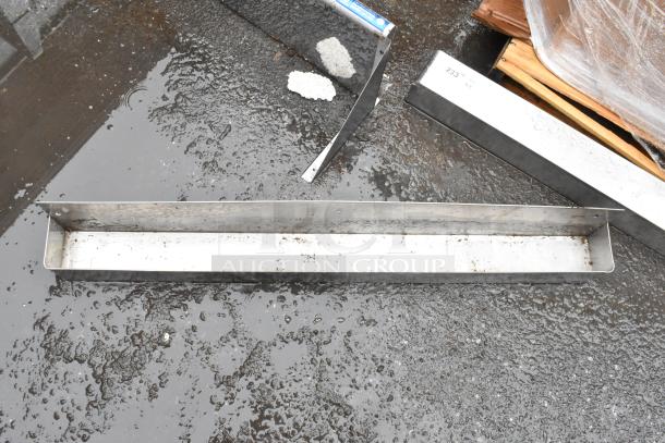 Stainless steel rectangular channel, used condition with rust marks. Labeled "233 W," ideal for construction or industrial use.