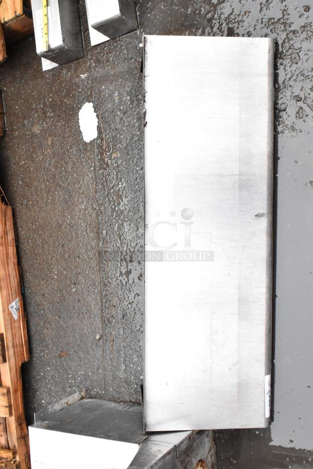 Stainless steel rectangular sheet, new condition, with slight surface marks. Label shows dimensions in inches.