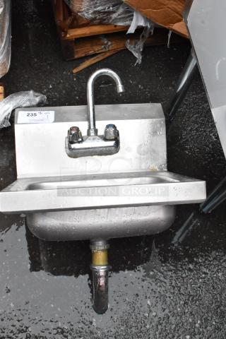 Stainless steel wall-mounted sink with dual handles and gooseneck faucet. Tag reads "235." Used condition.
