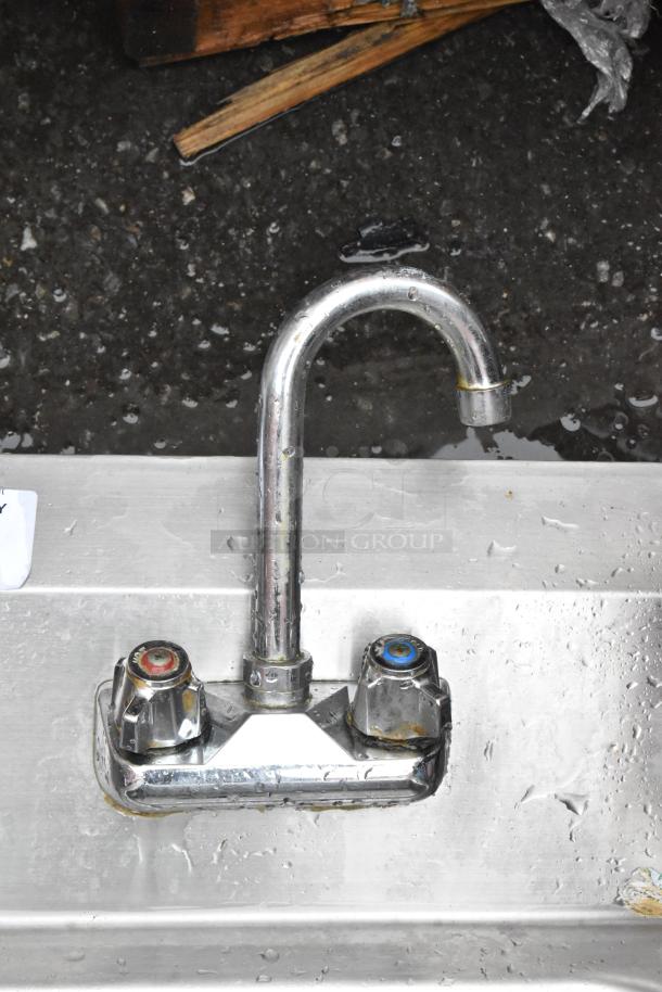 Chrome kitchen faucet with dual temperature dials, displaying wear and water spots, suitable for repair or restoration.