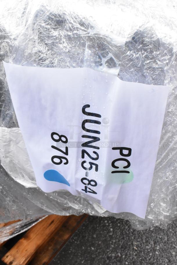 Wrapped pallet with visible label "PCI 876 JUN25-84," indicating model and date, wrapped in plastic. Condition: sealed.