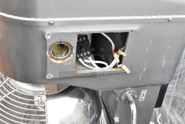 Industrial mixer with open panel revealing wiring and circuits. Signs of rust and wear. Potential repair needed.