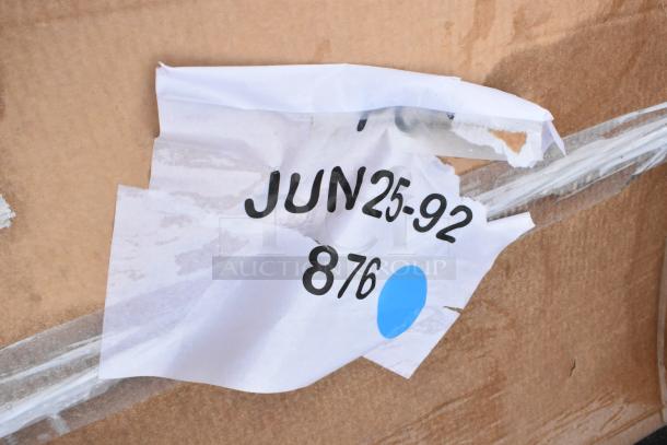 Torn paper on cardboard with "JUN 25-92" and "876" printed, blue dot, indicates date and identifier.