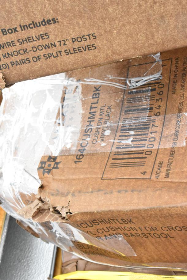 Damaged cardboard box containing metal wire shelves and split sleeves, labeled "CUSH MTL BK," sealed with plastic wrap.