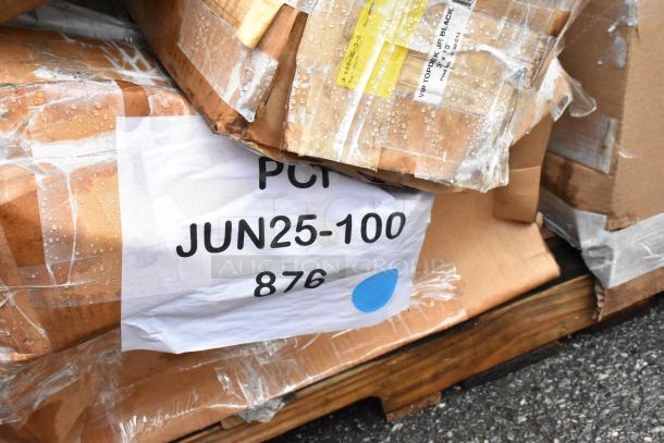Pallet with wrapped cardboard boxes, labeled "PCI JUN25-100 876," some water droplets visible on the surface.