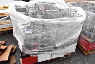 Wrapped stainless steel vending machine parts on a pallet. Protective plastic wrap with label "240 1 V XL". Ideal for resale.