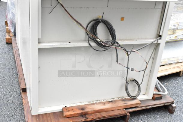 Industrial equipment backside with exposed wires, mounted on a wooden pallet. Visible discoloration and wear suggest used condition.