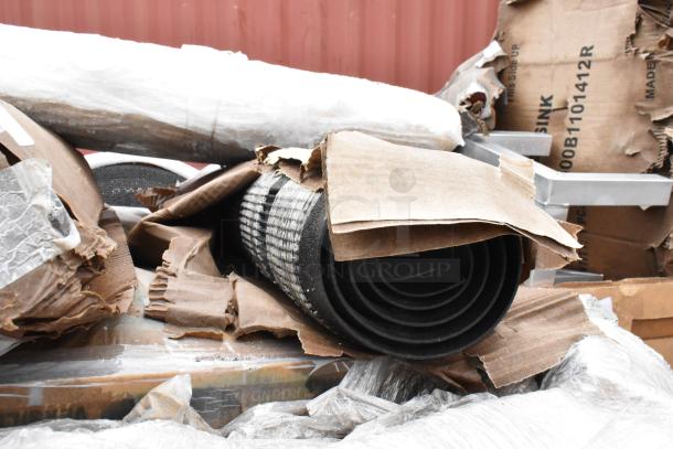 Rolled rubber mats wrapped in cardboard packaging, partially unwrapped. Condition appears new, with visible shipping labels.