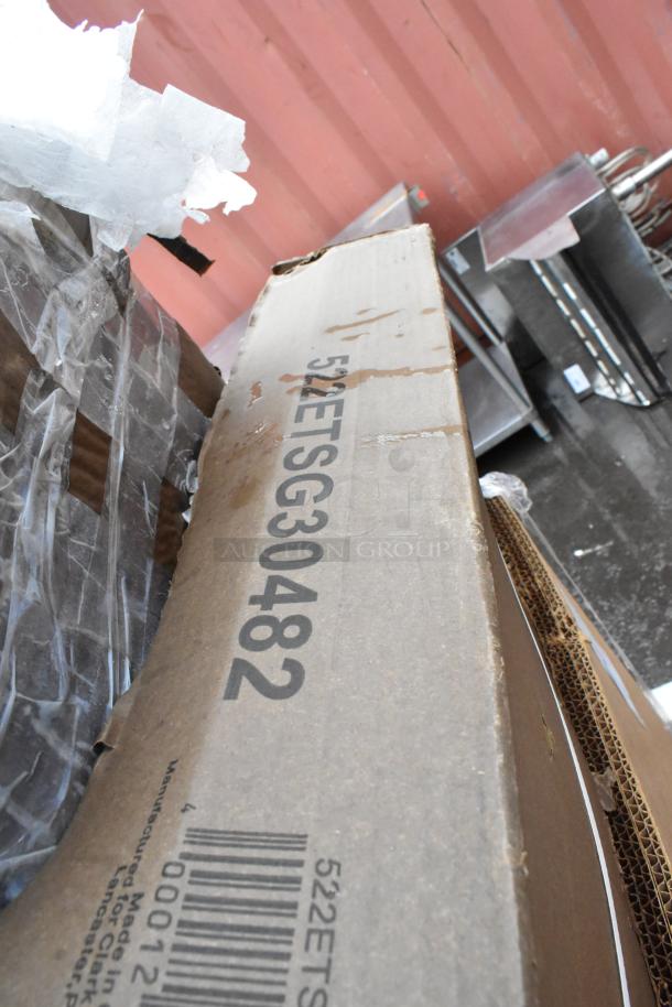 Cardboard box with visible markings "522ETSG30482" and barcode, indicating identification for shipping or inventory. Box shows some wear.