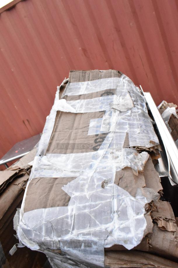 Damaged cardboard box with torn clear tape on a red metal background. Box shows signs of wear and tear.