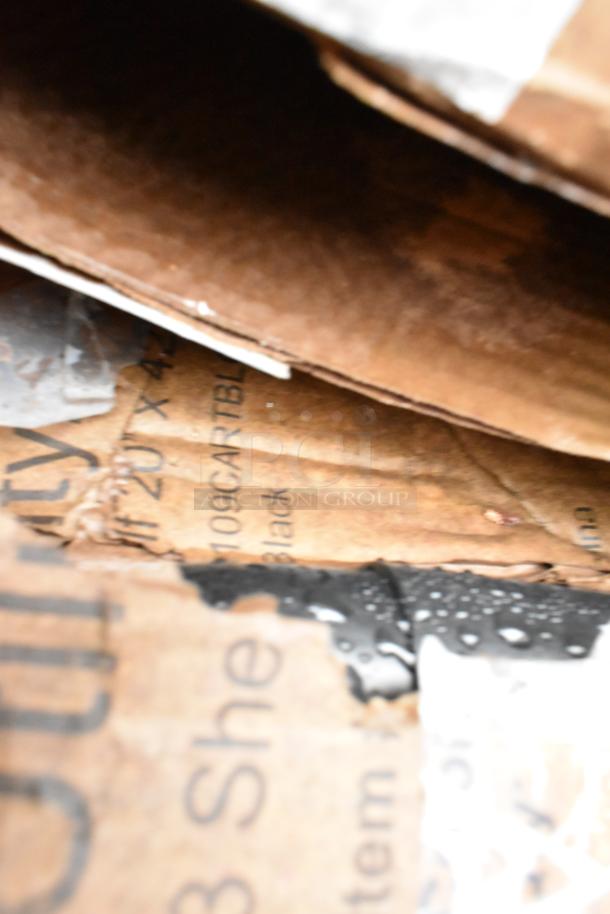 Close-up of a wet cardboard box with visible markings indicating "20 x 42," "109," and "Black." Box appears worn and damp.