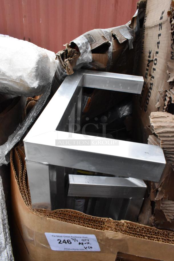 Stack of stainless steel table frames, new condition, in original packaging. Label reads "246, 1 Qty, Apx. x10."