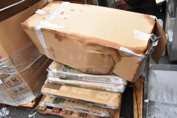 Damaged cardboard boxes stacked on a pallet, held with plastic wrap and tape, showing water stains and wear.