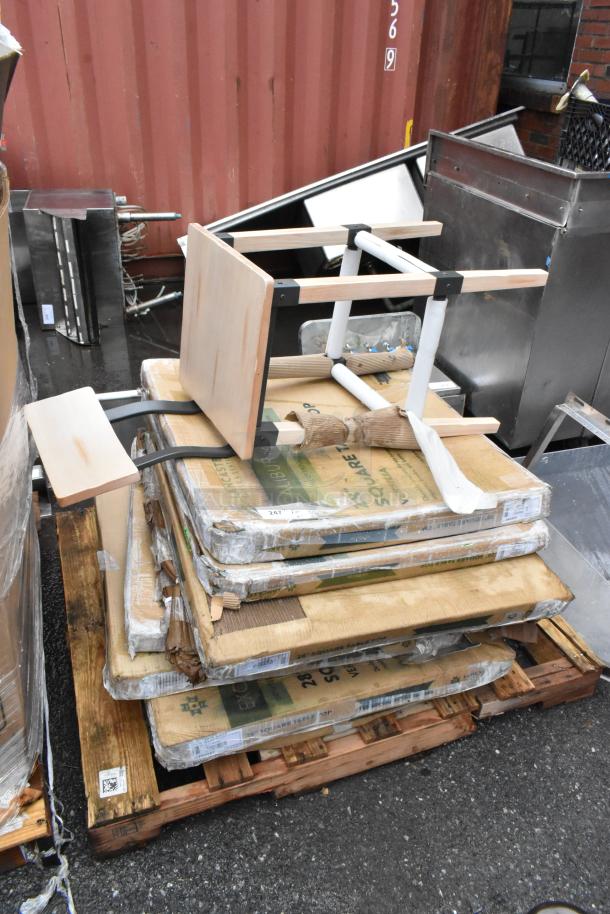 Wooden pallets stacked, holding flat-packed furniture, including a disassembled chair. Items appear unused but stored outdoors.