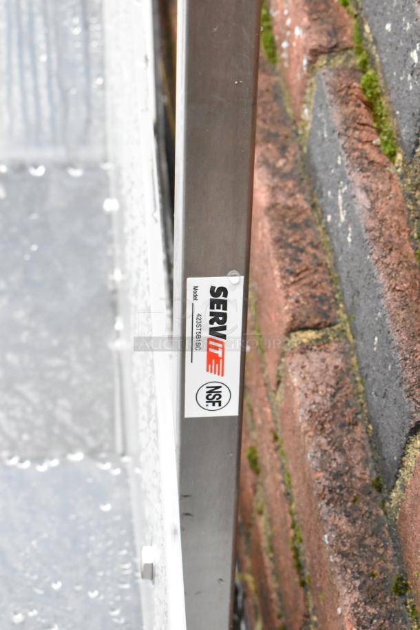 Metal side panel with a ServIt label, model 423ST519SC, NSF certified, against a brick wall.