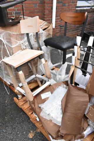Set of wooden and metal chairs on a pallet. One chair has water droplets. Tags visible. Unassembled, in new condition.