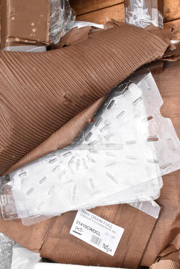 Clear polycarbonate tray drain with slotted design, labeled "21410CWDCL," in original packaging with some wear.