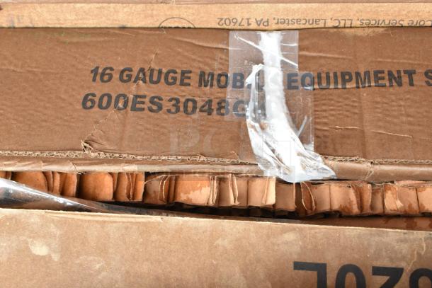 Cardboard box labeled "16 Gauge Mobile Equipment," model 600ES3048, slightly damaged with visible tape and corrugated contents.
