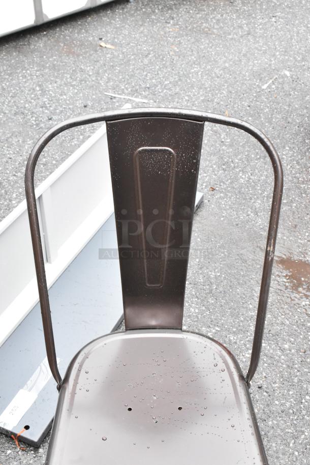 Brown metal chair with raindrops on the seat and backrest, showing a sturdy design. Some light wear visible.