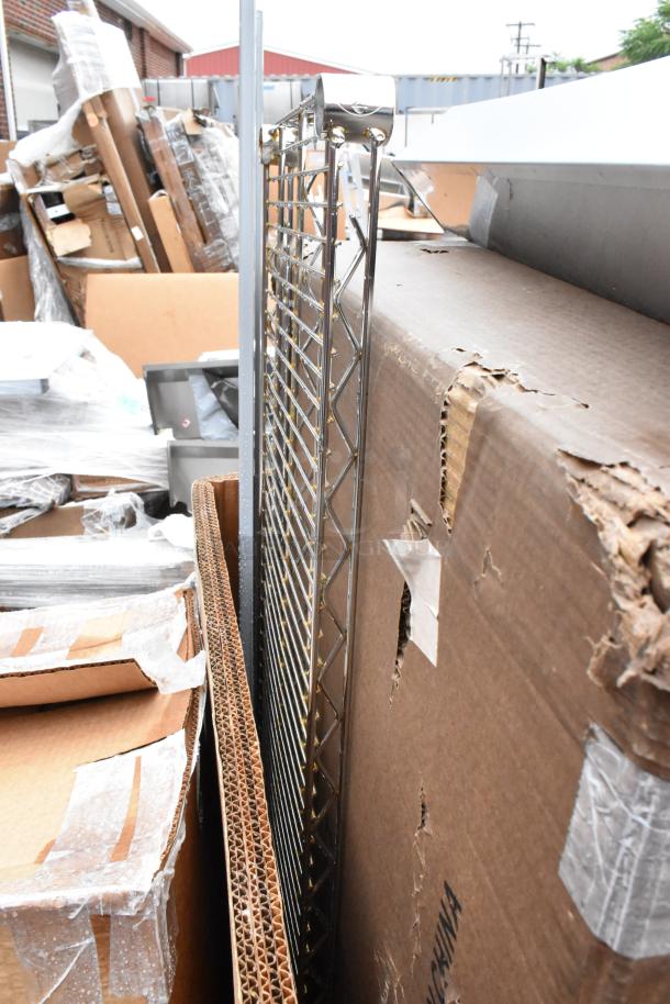 Metal shelving unit, chrome finish, new condition, partially unboxed. Packaging shows some wear. Ideal for storage use.