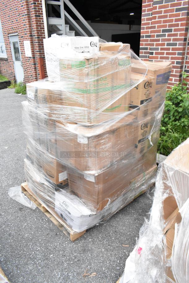 Pallet of assorted boxed goods wrapped in plastic, containing disposable food service supplies, stored outdoors.