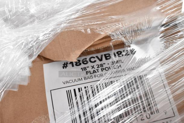 Cardboard box with transparent wrap showing label "#18CVB1828", "18” x 28” flat pouch", "vacuum bag for chamber machine".