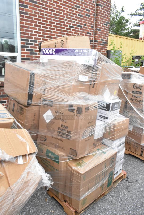 Pallet with assorted boxes wrapped in plastic, including food service film, sealed containers, and vinyl gloves.